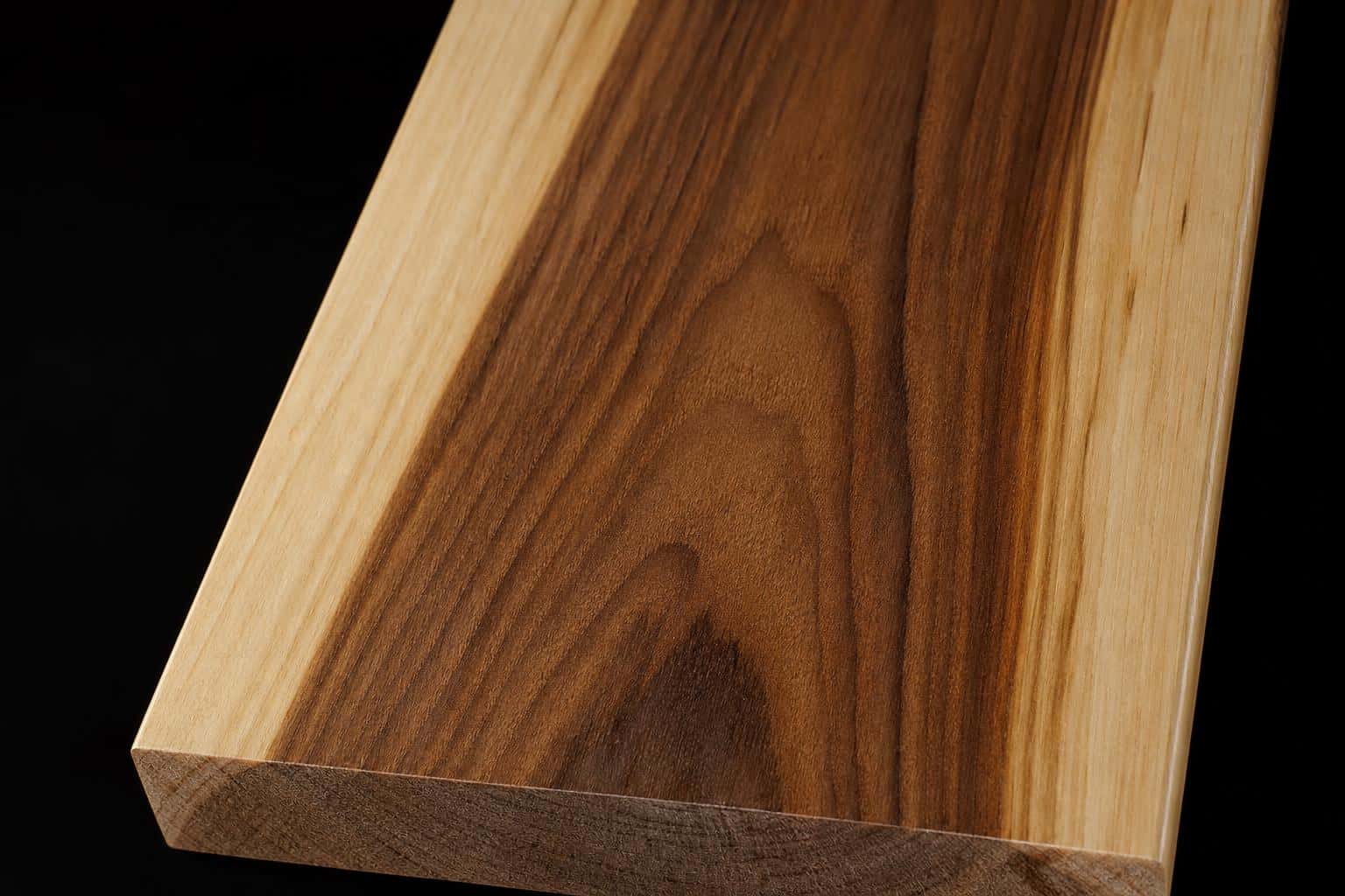 Hickory board with dark brown heartwood between pale cream sapwood edges, close-up of the face and end