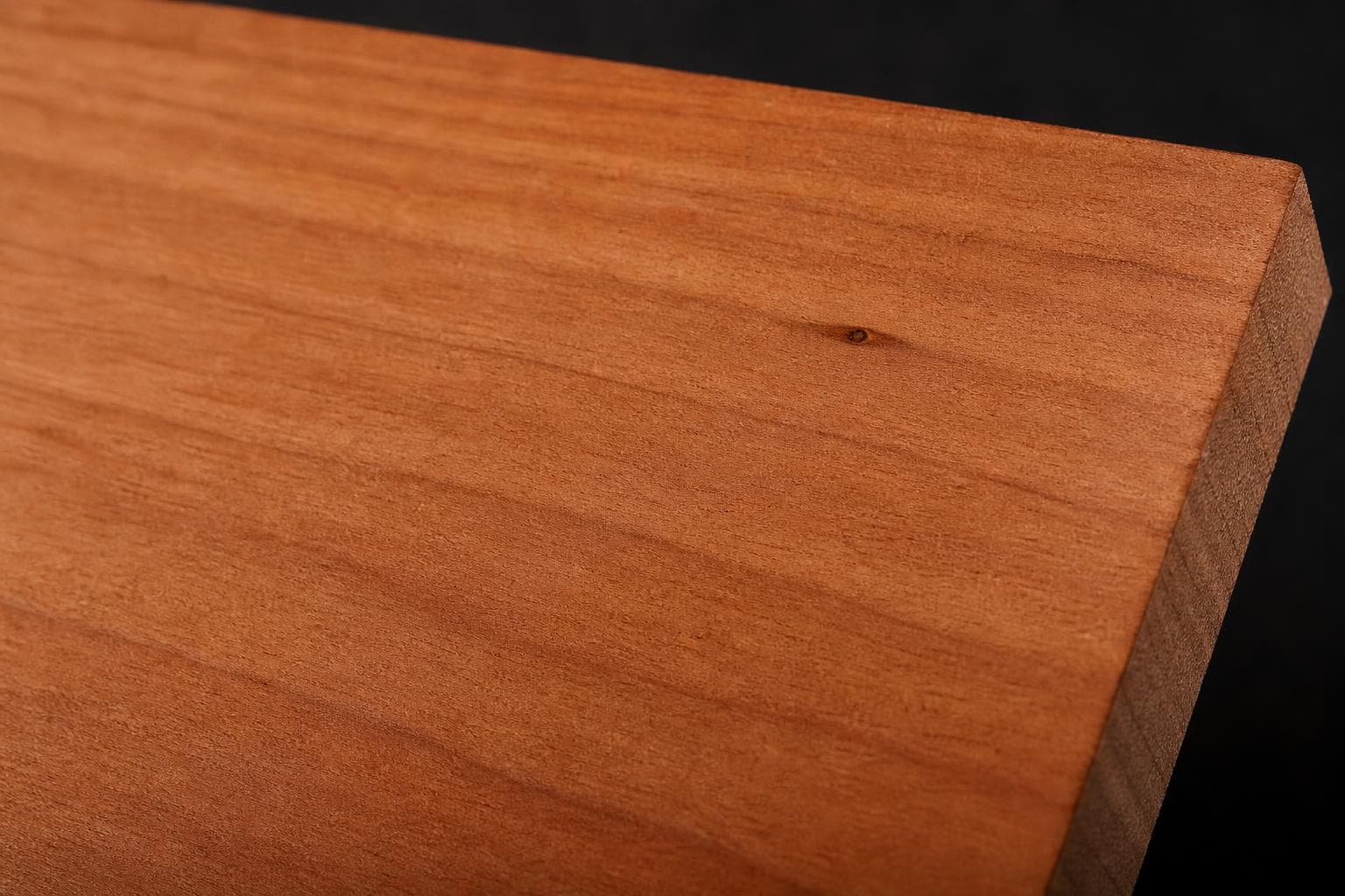Cherry board with a warm reddish-brown face and fine, even grain, close-up of the face and edge