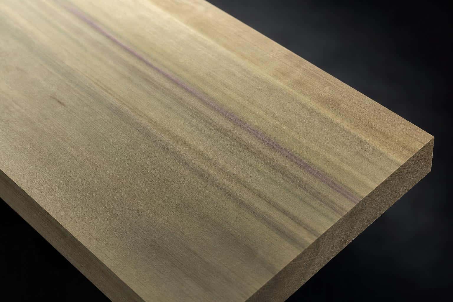 Poplar board with a pale olive-green face and a purple mineral streak, close-up of the face and edge