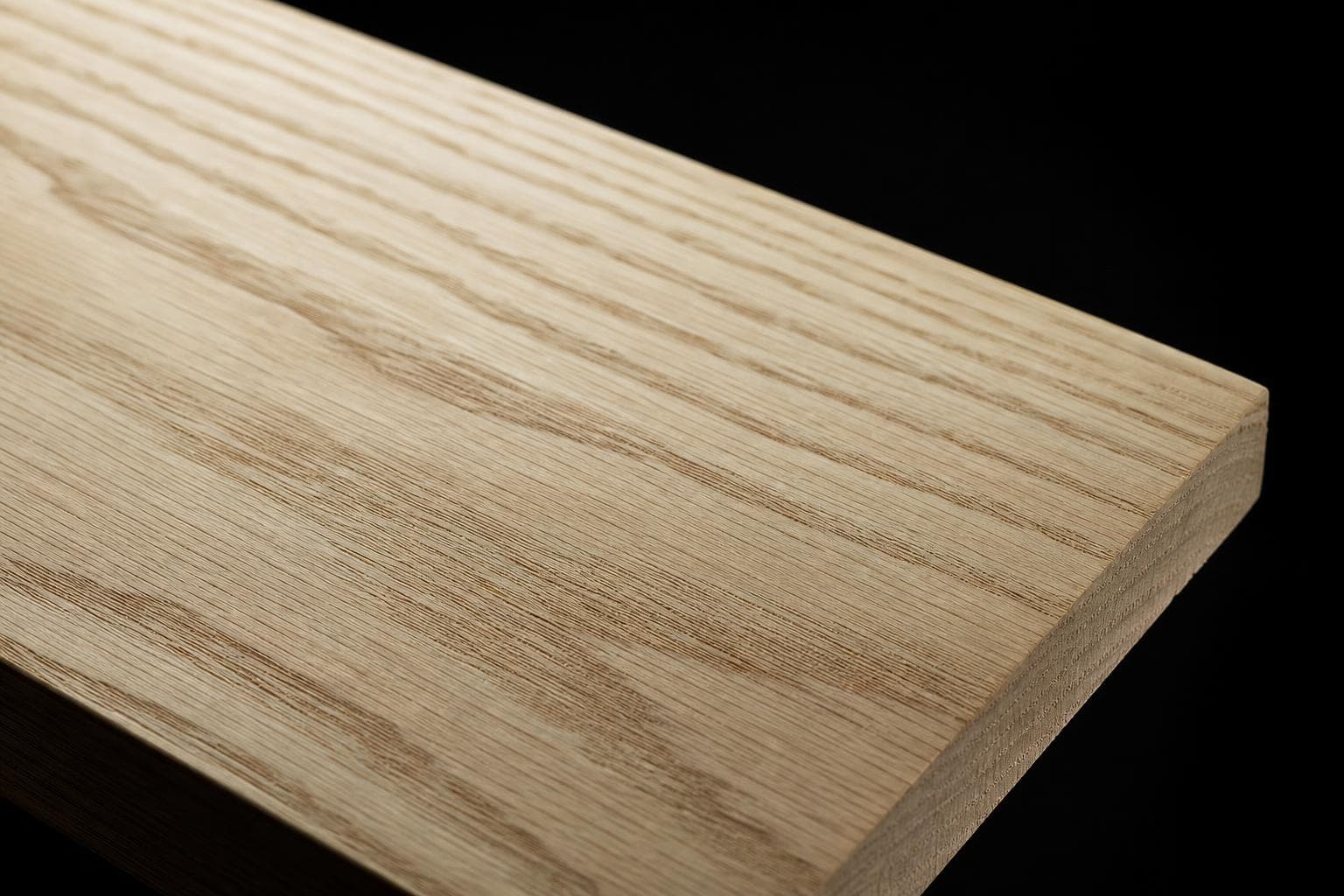 White ash board with a pale face and bold, open cathedral grain, close-up of the face and edge