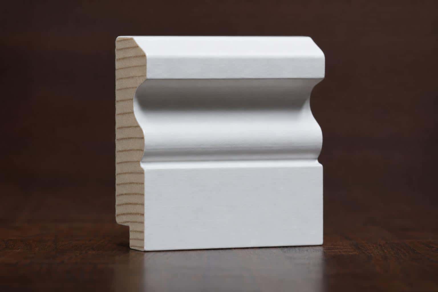 Primed white door casing with a cove and bead profile, cut end showing the bare wood