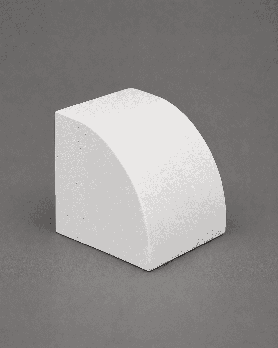 Short piece of primed white quarter round, showing its rounded face and square back