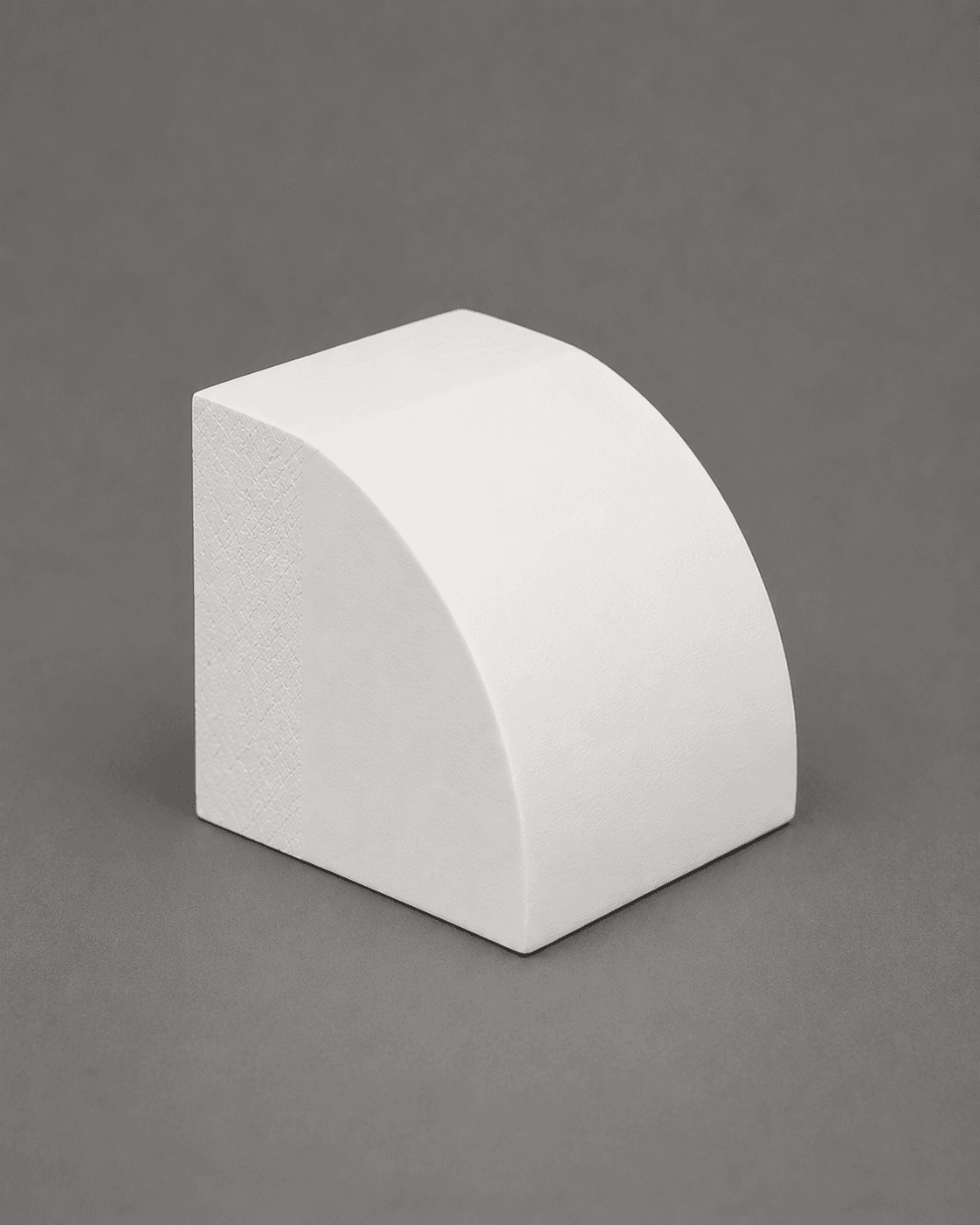 Short piece of primed white quarter round, showing its rounded face and square back